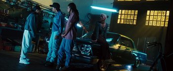 Movie still from “Set It Off” (1996), directed by F. Gary Gray – A group of people sitting on top of a car in the dark; Wide shot, Low angle