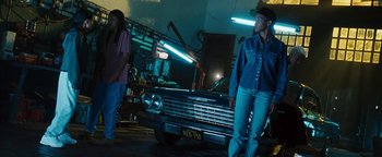 Movie still from “Set It Off” (1996), directed by F. Gary Gray – A couple of people standing next to an old car; Wide shot, Low angle