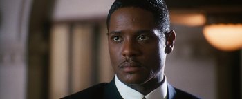 Movie still from “Set It Off” (1996), directed by F. Gary Gray – A person wearing a suit and tie; Close Up shot, Low angle