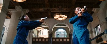 Movie still from “Set It Off” (1996), directed by F. Gary Gray – Two people are playing a video game in a building; Medium shot, Low angle