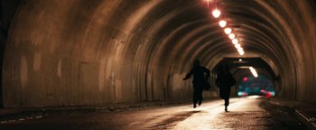 Movie still from “Set It Off” (1996), directed by F. Gary Gray – A person running in a tunnel with a light shining on it; Wide shot, High angle