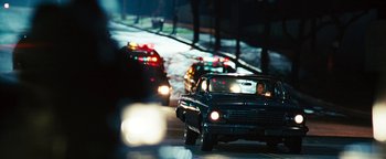 Movie still from “Set It Off” (1996), directed by F. Gary Gray – A man driving a car down a street at night; Wide shot, Over the shoulder angle