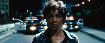 Movie still from “Set It Off” (1996), directed by F. Gary Gray – A person wearing a plaid shirt near a street; Close Up shot, High angle