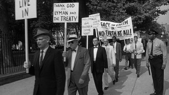 Movie still from “Seven Days in May” (1964), directed by John Frankenheimer – A black and white photo of people holding protest signs; Medium shot, Low angle