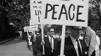 Movie still from “Seven Days in May” (1964), directed by John Frankenheimer – A black and white photo of people holding protest signs; Medium shot, High angle