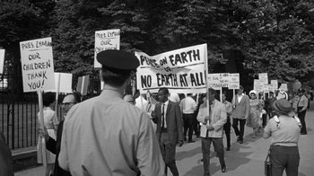 Movie still from “Seven Days in May” (1964), directed by John Frankenheimer – A black and white photo of people holding protest signs; Medium shot, High angle