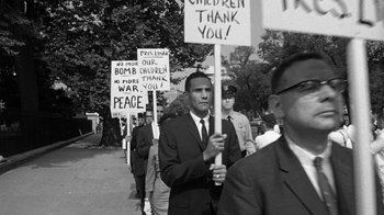 Movie still from “Seven Days in May” (1964), directed by John Frankenheimer – A group of men holding signs that say " children thank you "; Medium shot, Low angle
