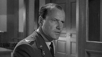 Movie still from “Seven Days in May” (1964), directed by John Frankenheimer – An old black and white photo of a man in a uniform; Close Up shot, Low angle