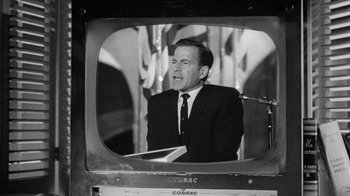 Movie still from “Seven Days in May” (1964), directed by John Frankenheimer – A black and white photo of a man in a suit and tie; Medium shot, Low angle
