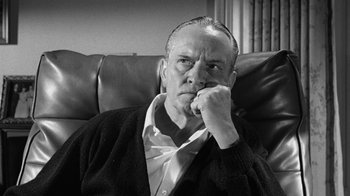Movie still from “Seven Days in May” (1964), directed by John Frankenheimer – An older man sitting on a leather couch; Close Up shot, Low angle