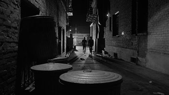 Movie still from “Seven Days in May” (1964), directed by John Frankenheimer – Two people walking down a dark alleyway at night; Wide shot, High angle
