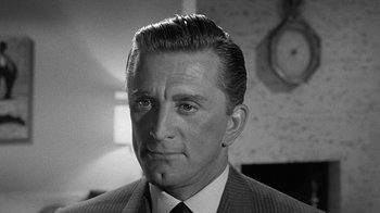Movie still from “Seven Days in May” (1964), directed by John Frankenheimer – Black and white photograph of a man in a suit and tie; Close Up shot, Low angle
