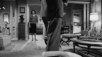 Movie still from “Seven Days in May” (1964), directed by John Frankenheimer – A man and a woman standing in a living room; Wide shot, Low angle