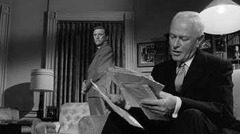 Movie still from “Seven Days in May” (1964), directed by John Frankenheimer – A man in a suit and tie sitting next to another man in a suit and tie; Medium shot, Over the shoulder angle
