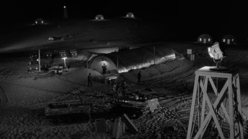 Movie still from “Seven Days in May” (1964), directed by John Frankenheimer – A black and white photo of people standing in the snow at night; Extreme Wide shot, High angle