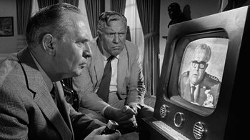 Movie still from “Seven Days in May” (1964), directed by John Frankenheimer – Two men are watching television in a living room; Medium shot, Over the shoulder angle