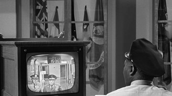 Movie still from “Seven Days in May” (1964), directed by John Frankenheimer – An old television with a man on the screen; Close Up shot, Over the shoulder angle