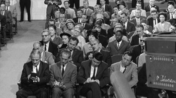 Movie still from “Seven Days in May” (1964), directed by John Frankenheimer – A group of men and women sitting in a room together; Wide shot, High angle