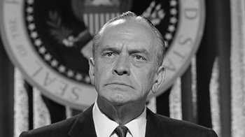 Movie still from “Seven Days in May” (1964), directed by John Frankenheimer – An old black and white photo of a man in a suit and tie; Close Up shot, Low angle