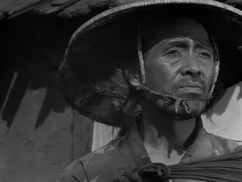Movie still from “Seven Samurai” (1954), directed by Akira Kurosawa – A man wearing a hat with feathers on his head; Close Up shot, Low angle