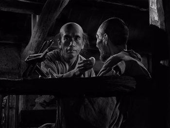Movie still from “Seven Samurai” (1954), directed by Akira Kurosawa – A man with a bald head is looking at another man with a bald head; Medium shot, Low angle
