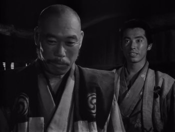 Movie still from “Seven Samurai” (1954), directed by Akira Kurosawa – Two men in traditional japanese garb standing next to each other; Close Up shot, Low angle