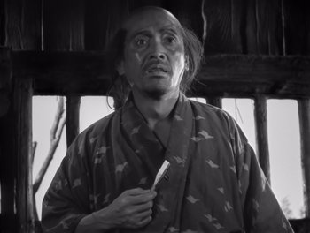 Movie still from “Seven Samurai” (1954), directed by Akira Kurosawa – A man in a robe holding a tooth brush; Medium shot, Low angle