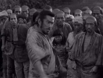 Movie still from “Seven Samurai” (1954), directed by Akira Kurosawa – Black and white photograph of a group of people in a line; Medium shot, High angle