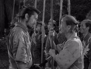 Movie still from “Seven Samurai” (1954), directed by Akira Kurosawa – A group of people standing around each other; Medium shot, Over the shoulder angle