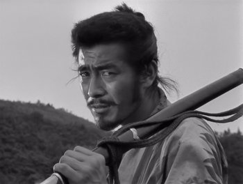 Movie still from “Seven Samurai” (1954), directed by Akira Kurosawa – Black and white photograph of a man holding a baseball bat; Close Up shot, Low angle