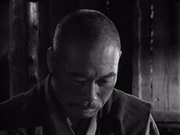 Movie still from “Seven Samurai” (1954), directed by Akira Kurosawa – An older man is looking down at his face; Close Up shot, Low angle