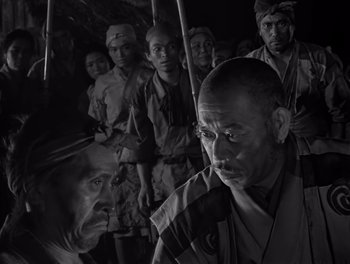 Movie still from “Seven Samurai” (1954), directed by Akira Kurosawa – Black and white photograph of a group of men in military garb; Close Up shot, High angle