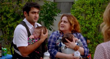 Movie still from “Sex Tape” (2014), directed by Jake Kasdan – A man and a woman holding a baby in a sling; Medium shot, Over the shoulder angle