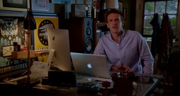 Movie still from “Sex Tape” (2014), directed by Jake Kasdan – A man sitting in front of a laptop computer on top of a desk; Medium shot, Over the shoulder angle