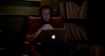 Movie still from “Sex Tape” (2014), directed by Jake Kasdan – A man sitting in front of an open laptop computer; Medium shot, High angle