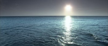 Movie still from “Sex and Lucía” (2001), directed by Julio Medem – The sun is setting over a body of water; Extreme Wide shot, High angle