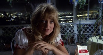 Movie still from “Shampoo” (1975), directed by Hal Ashby – A woman in a white dress is sitting on a porch; Close Up shot, Over the shoulder angle