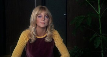 Movie still from “Shampoo” (1975), directed by Hal Ashby – A woman with long blonde hair wearing a yellow and purple shirt; Close Up shot, Over the shoulder angle