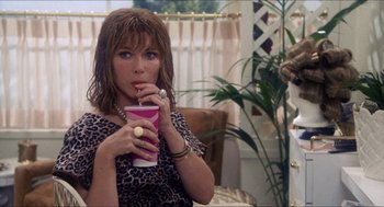 Movie still from “Shampoo” (1975), directed by Hal Ashby – A woman sitting in a chair holding a drink; Medium shot, Over the shoulder angle