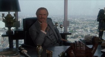 Movie still from “Shampoo” (1975), directed by Hal Ashby – An older man sitting in a chair in front of a window; Medium shot, Over the shoulder angle
