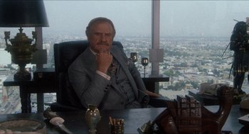 Movie still from “Shampoo” (1975), directed by Hal Ashby – An older man sitting in a chair in front of a window; Medium shot, Low angle