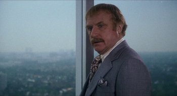 Movie still from “Shampoo” (1975), directed by Hal Ashby – An older man with a mustache in front of a large window; Close Up shot, Low angle