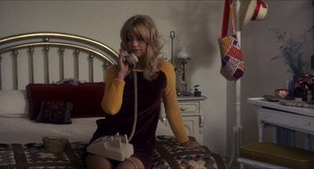 Movie still from “Shampoo” (1975), directed by Hal Ashby – A woman sitting on a bed talking on a phone; Medium shot, High angle