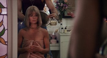 Movie still from “Shampoo” (1975), directed by Hal Ashby – A woman sitting in front of a mirror in a bathroom; Medium shot, Over the shoulder angle