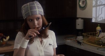 Movie still from “Shampoo” (1975), directed by Hal Ashby – A woman holding a pen in her mouth; Close Up shot, Low angle