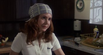 Movie still from “Shampoo” (1975), directed by Hal Ashby – A woman wearing a hat sitting in a room; Close Up shot, Over the shoulder angle
