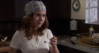 Movie still from “Shampoo” (1975), directed by Hal Ashby – A woman holding a piece of food in her hand; Close Up shot, Over the shoulder angle