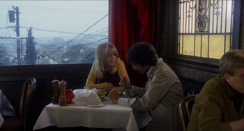 Movie still from “Shampoo” (1975), directed by Hal Ashby – A man and a woman sitting at a dinner table; Medium shot, High angle
