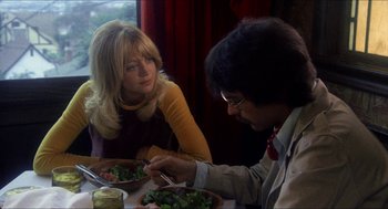 Movie still from “Shampoo” (1975), directed by Hal Ashby – Two people sitting at a table with a plate of food; Medium shot, Over the shoulder angle