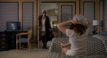 Movie still from “Shampoo” (1975), directed by Hal Ashby – A woman is standing in front of another woman in a room; Wide shot, Over the shoulder angle